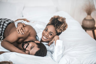 couple in bed about to use a sex toy