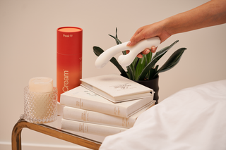 A woman holding Peach and Cream Vibrator on her nightstand