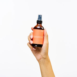 Hand holding a bottle of Peach and Cream 'Cleam' sex toy cleaner on a white background