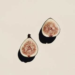 Two halved figs on a cream surface