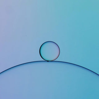 a single drop resting on a blue curve
