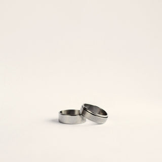 two silver rings on a white surface