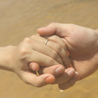 Two hands holding each other in warm light