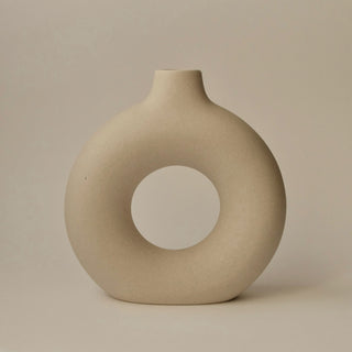 a round ceramic vase with an open centre
