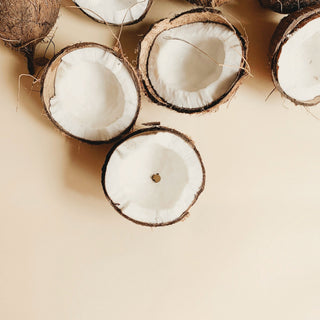 Halved coconuts on a beige surface