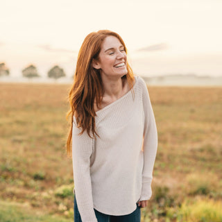A smiling woman standing in a golden field