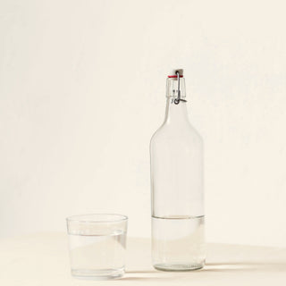 a glass bottle of water and a glass