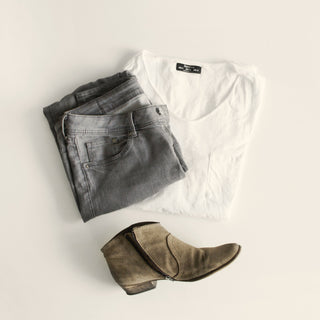folded clothes and boots laid out for packing