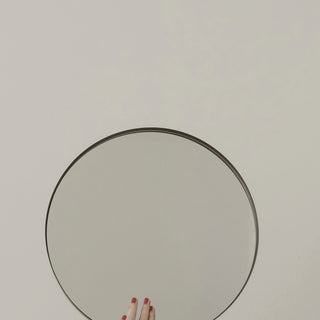 a round hand mirror on a light background