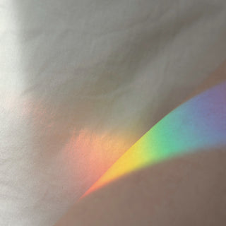 A soft rainbow of light across a pale wall