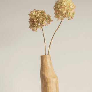 Dried hydrangea stems in a wooden vase