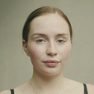 Portrait of a calm woman against a soft green background