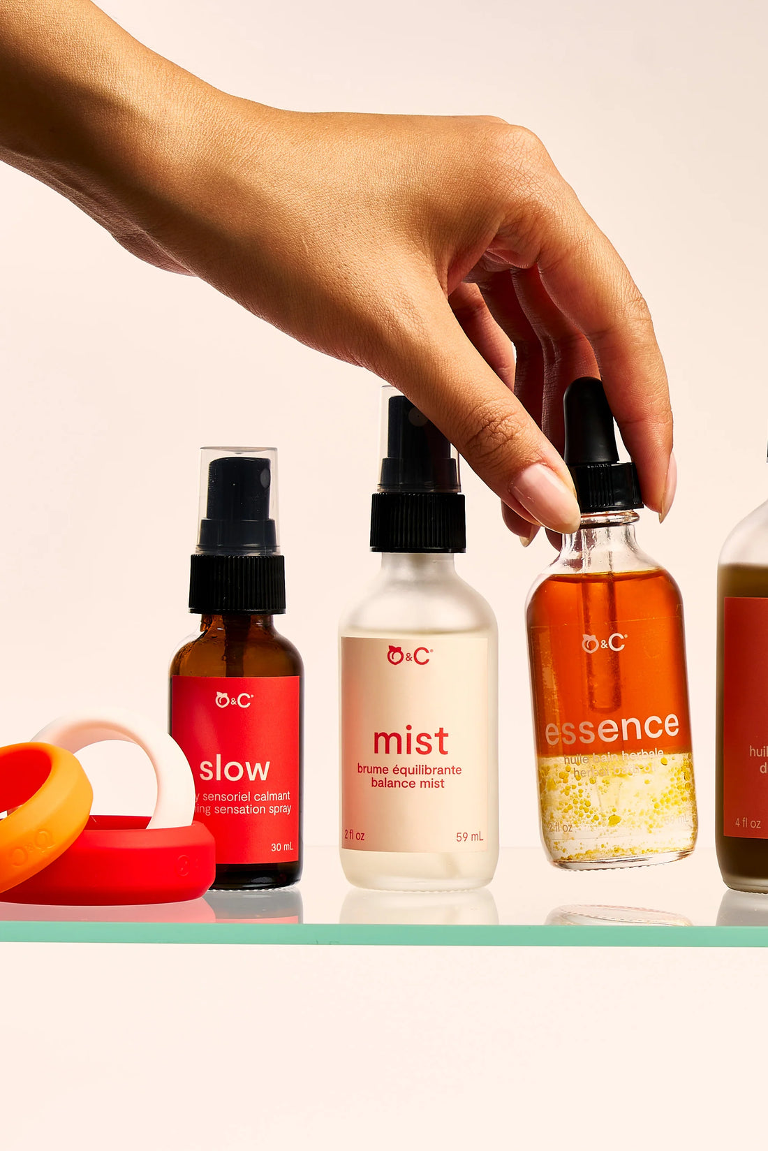 a hand picks a bottle from a shelf of peach & cream care