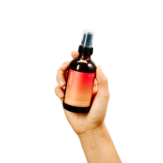 hand holding peach & cream clean plant-based sex toy cleaner spray bottle