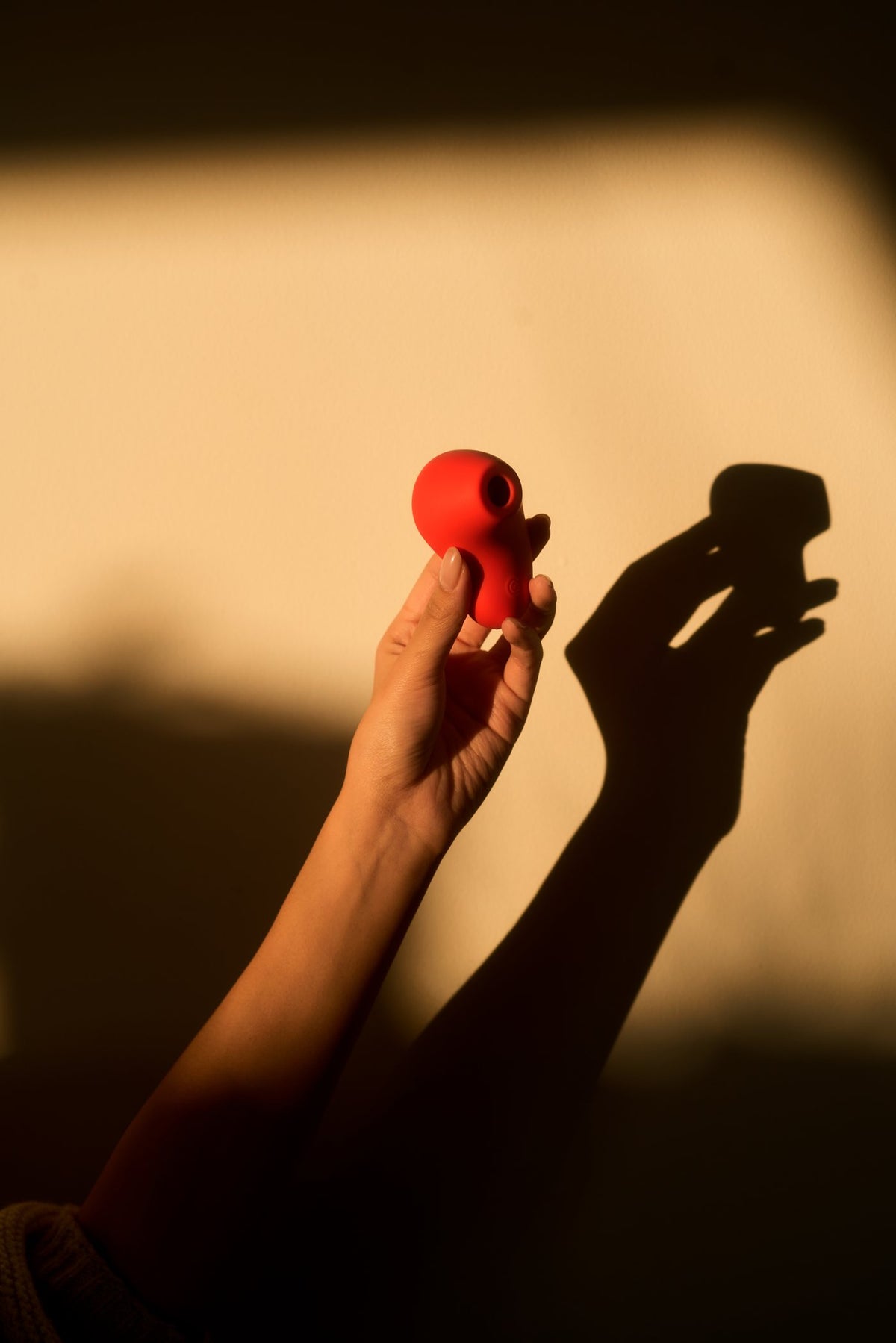a hand holds aura up to the evening light
