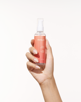A woman hand holding Peach and Cream personal lubricant Honey
