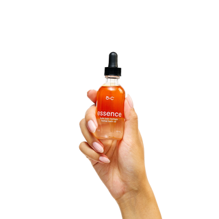 Hand holding a bottle of Peach and Cream botanical oil 'essence' 