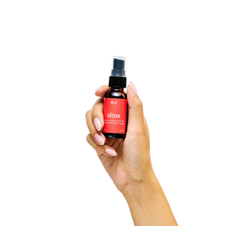 Hand holding a Peach and Cream calming sensation spray 'slow'