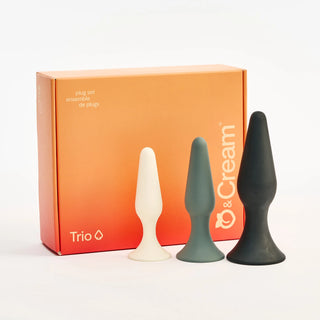 Three Peach and Cream silicone plugs in white, grey, and black with a 'Trio' box on a white background.